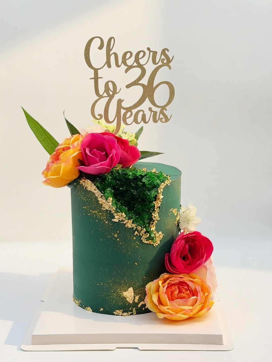 Pastel verde con flores coloridas y detalles dorados